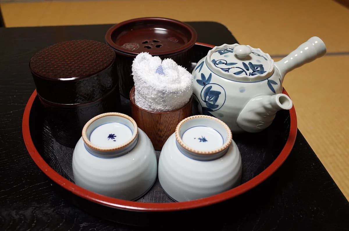 A Japanese tea tray with a teapot and two yunomi cups arranged for service.